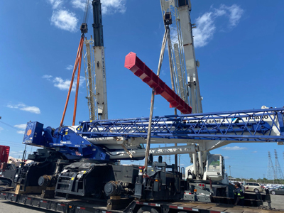 Export Logistics & Shipping, Inc. transfers Tadano GR1000XL-5 crane with jib boom and swing away to flat rack